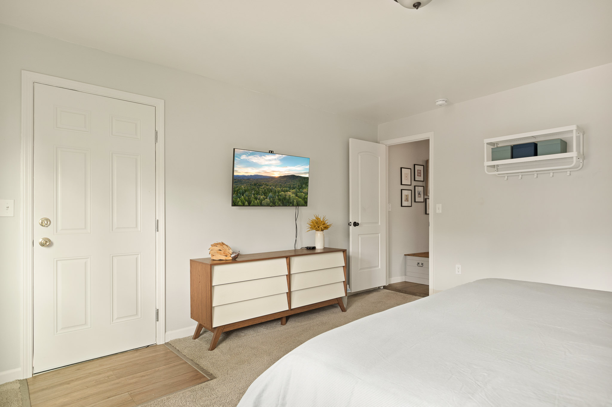 Neutral king bedroom with dresser and wall-mounted TV at The Big Bear Cubhouse