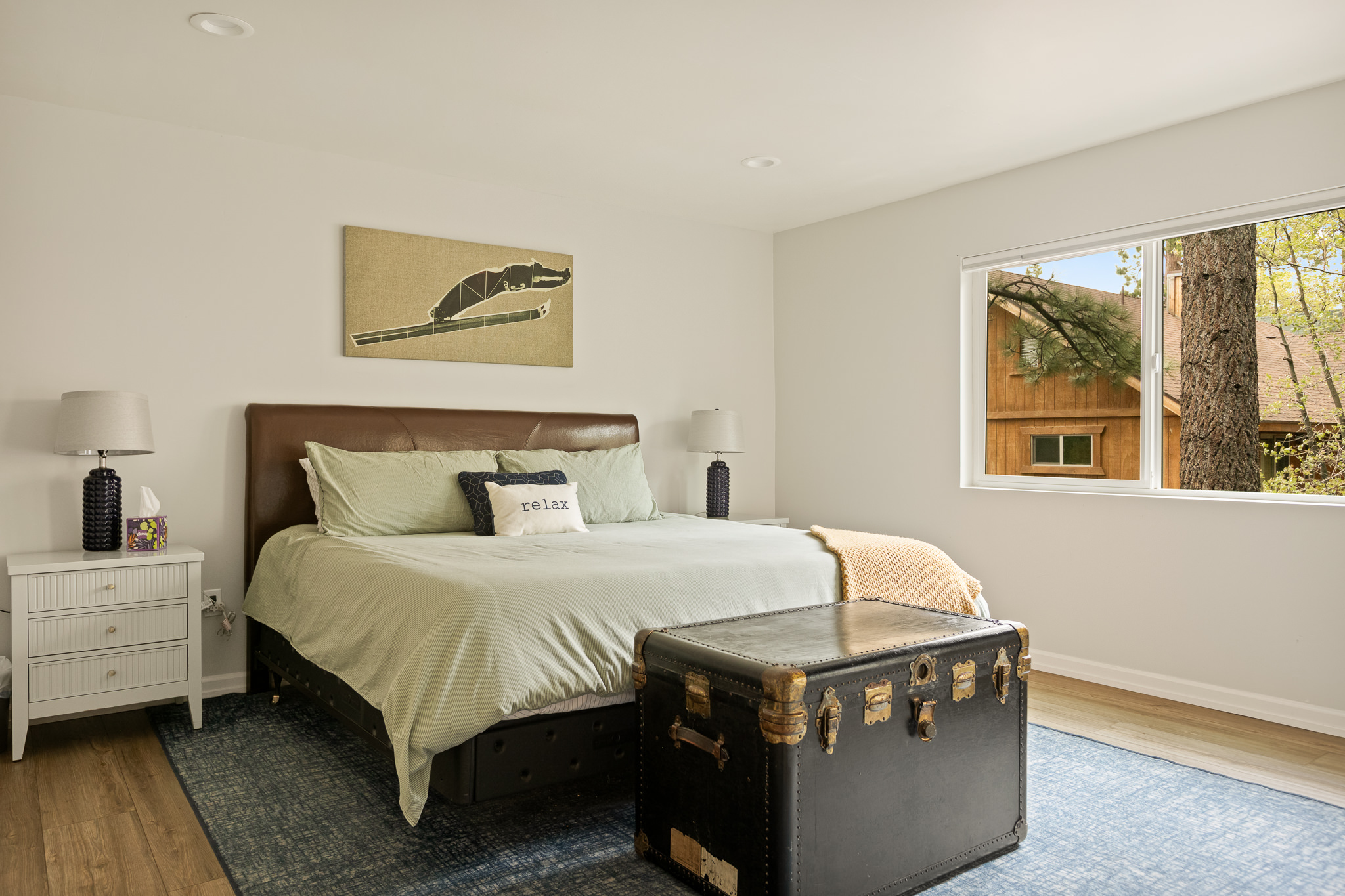 King bedroom with yellow accents and vintage trunk at The Big Bear Cubhouse