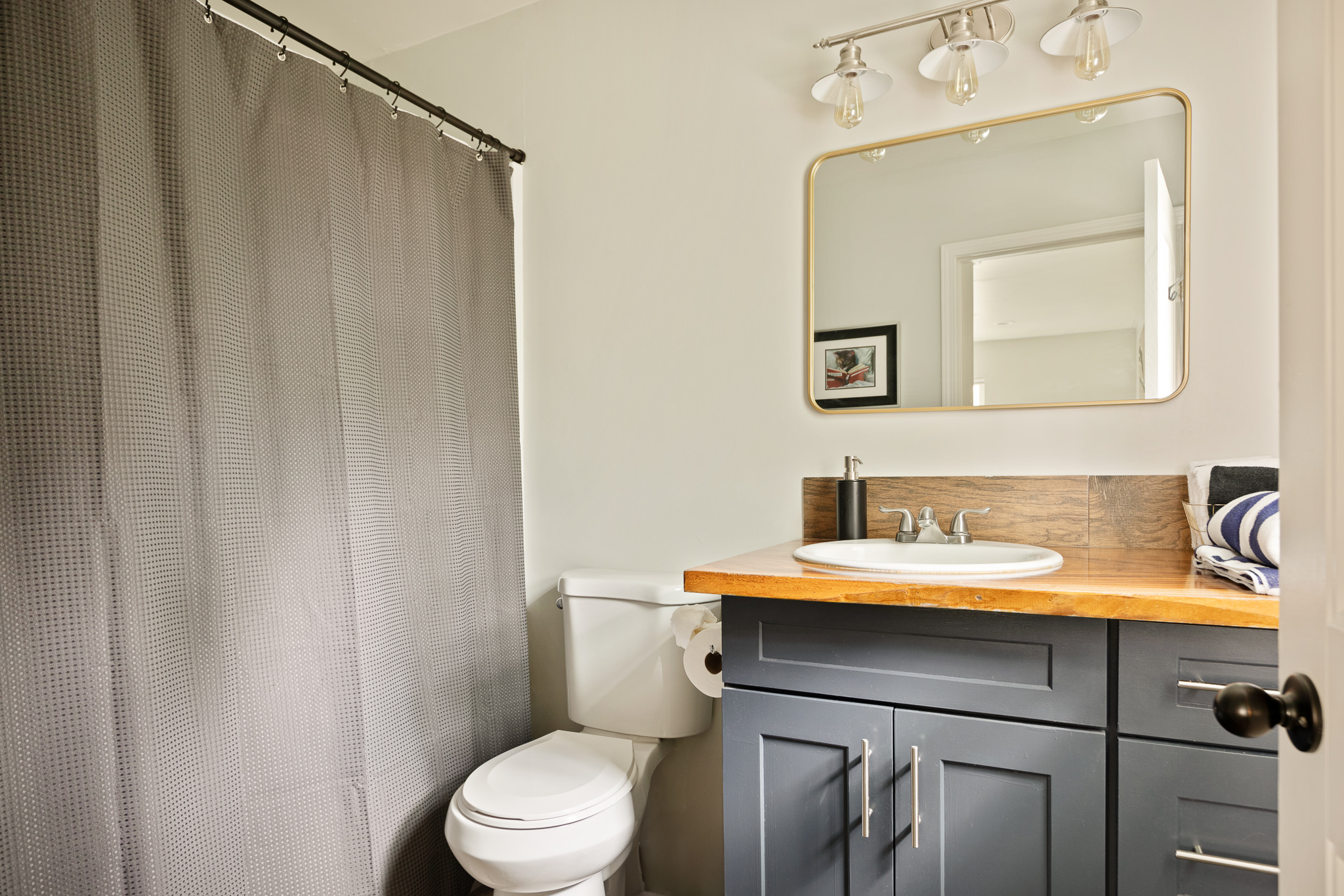 Navy vanity bathroom with modern fixtures at The Big Bear Cubhouse